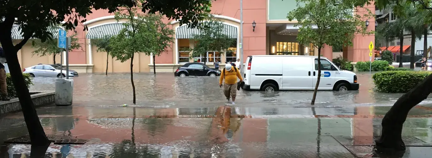 man walks through flood in Miami